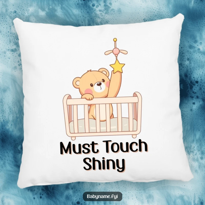 Funny teddy bear reaching for a crib mobile, depicted on a soft, decorative pillow. A sweet and humorous accent.