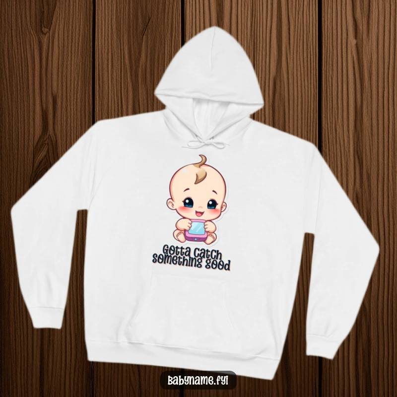 Funny hoodie with a smiling baby character reaching out to touch a soft, colorful mobile, symbolizing exploration.