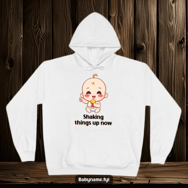 Funny hoodie with a cheerful baby character joyfully shaking a colorful rattle, embodying pure excitement and fun.
