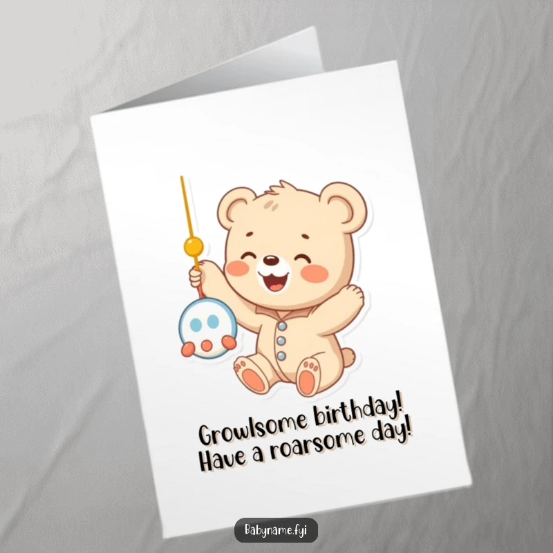 Funny Free Printable Birthday Card: Baby bear cub in a onesie reaching happily for a mobile, spreading birthday cheer.